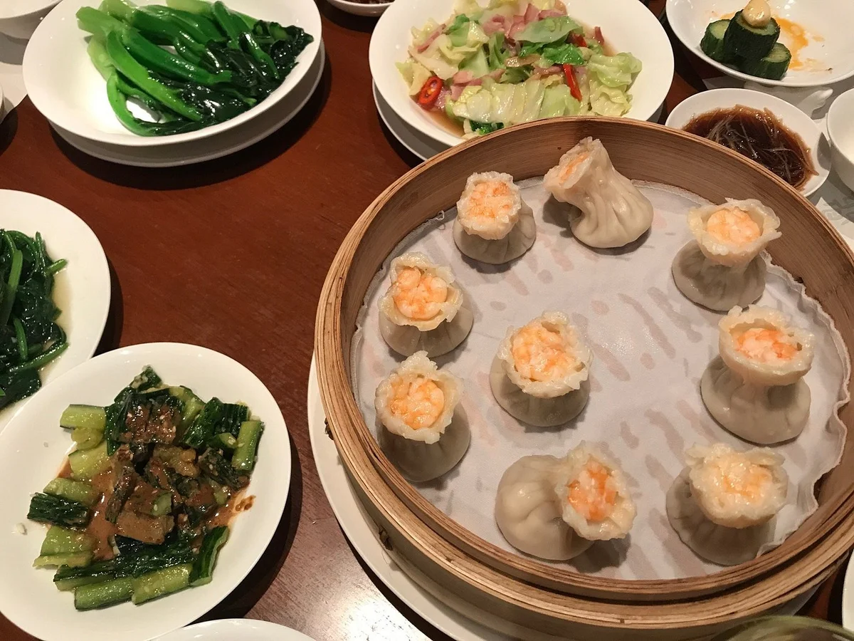 A classic Din Tai Fung spread: soup dumplings, fried rice, and the signature hot and sour soup