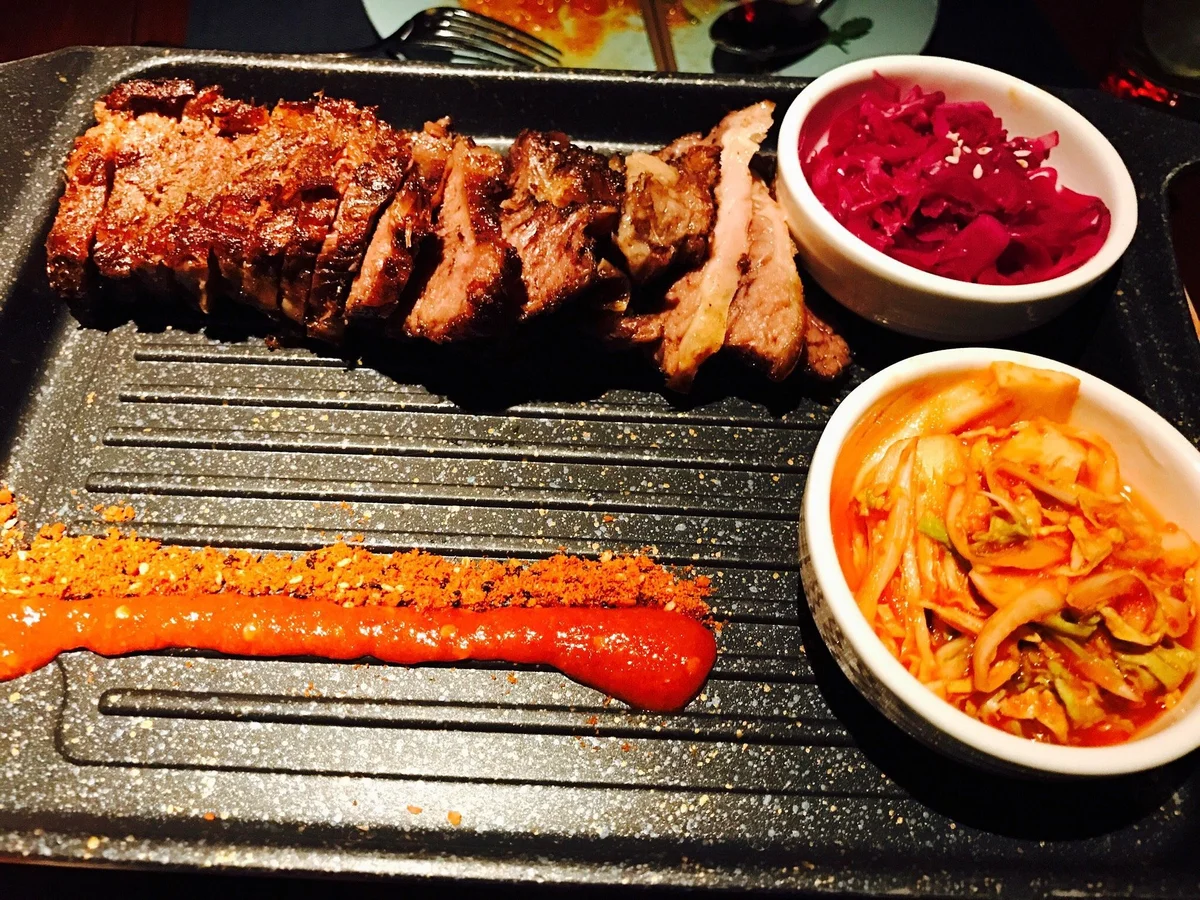 Tea-smoked duck with lacquered skin, served with pancakes, hoisin, and scallions for wrapping