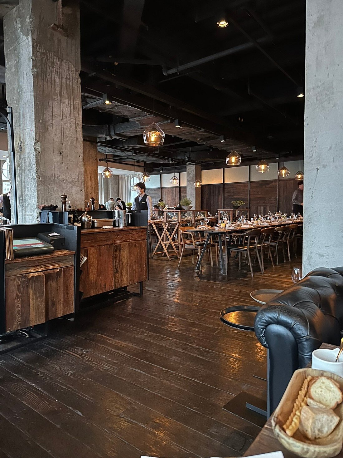 Mercato's dining room on the 6th floor of Six Stories — exposed brick, reclaimed wood, and floor-to-ceiling windows framing the Pudong skyline